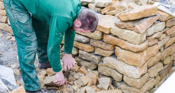 man building a sandstone wall