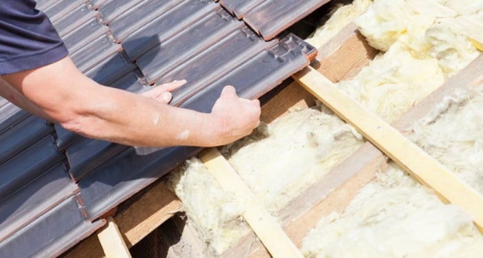 person replacing roof tiles