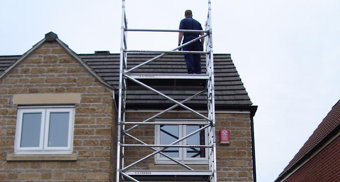 scaffolding on a house with man standing on it