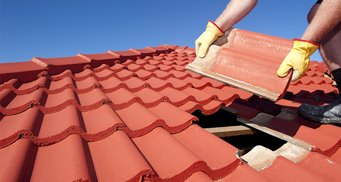 hands replacing roof tile