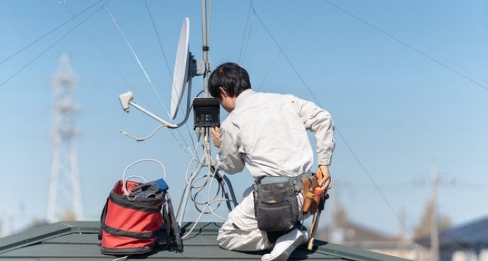 man installing aerial on roof