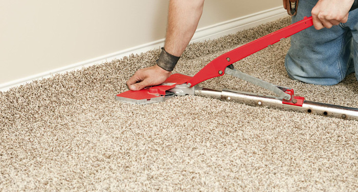 person using carpet fitting tool