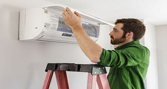 Man installing air source heat pump on wall