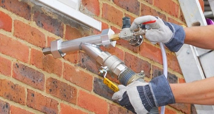 person installing cavity wall insulation