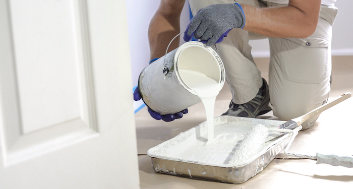 painting pouring out paint into a tray before decorating