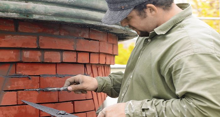 Man repointing brick wall