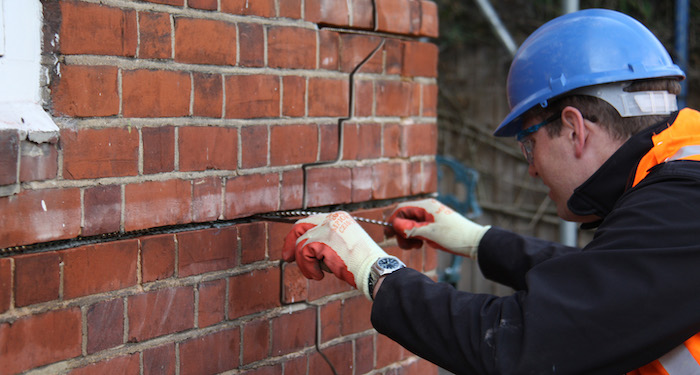 Tradesperson repointing brickwork