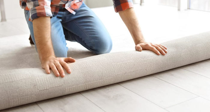 person unrolling carpet