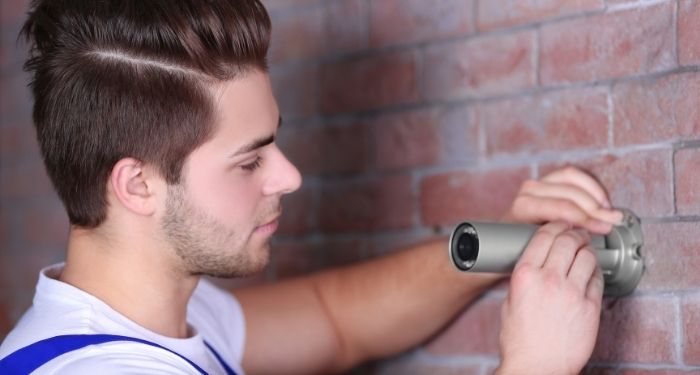 Man installing security camera