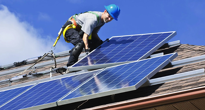 man with hardhat installing solar panels