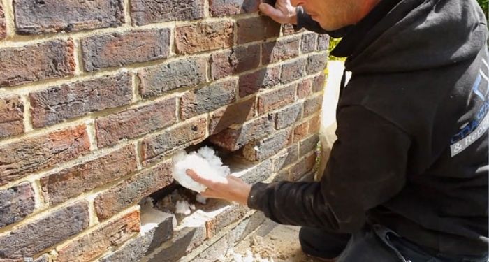man inserting to cavity wall insulation