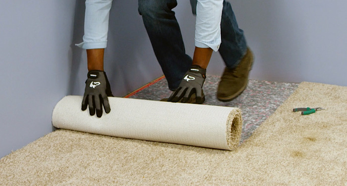 person removing carpet from room