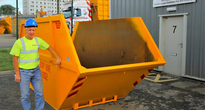 man standing next to a 14 yard skip