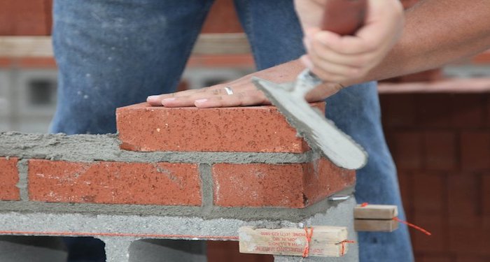 Tradesperson using the beaded pointing method on bricks