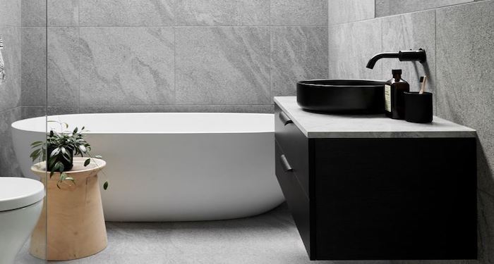 Grey and black bathroom with white bath