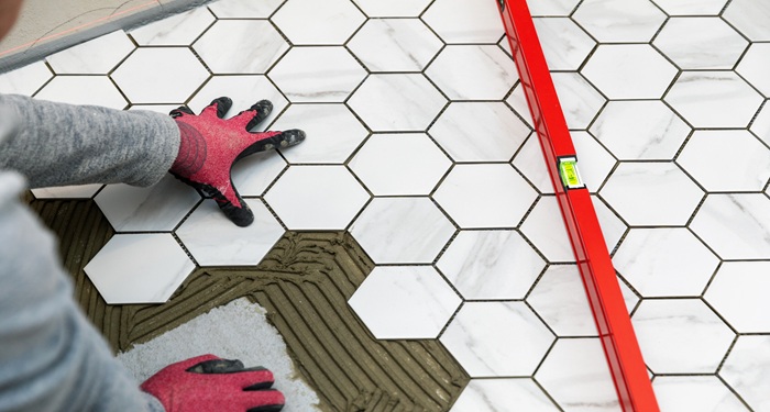Person installing floor tiles