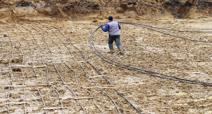 Man laying GSHP pipes