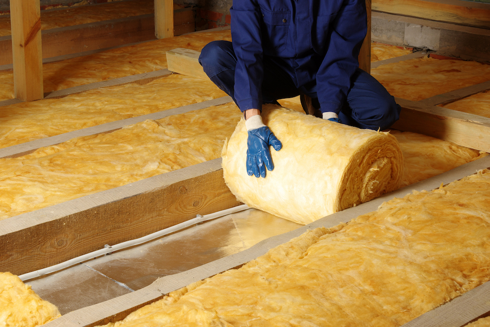 person rolling out insulation