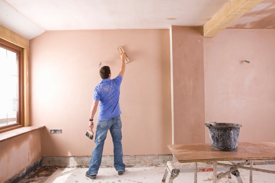 man plastering a room
