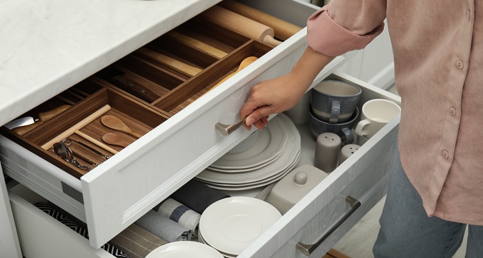 Hand tidying kitchen drawer