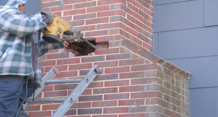 person working on brick chimney