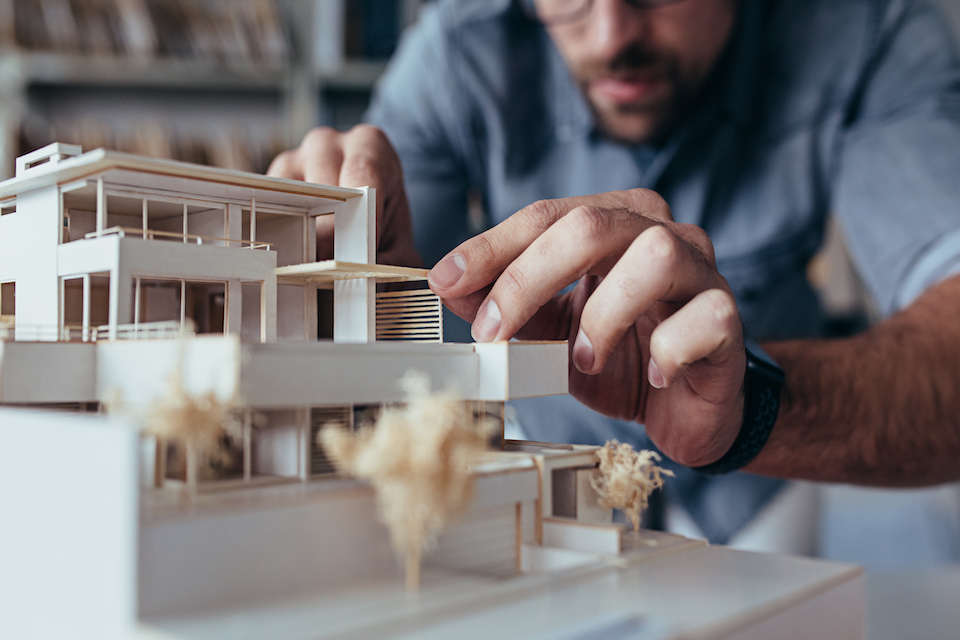 person looking at house model