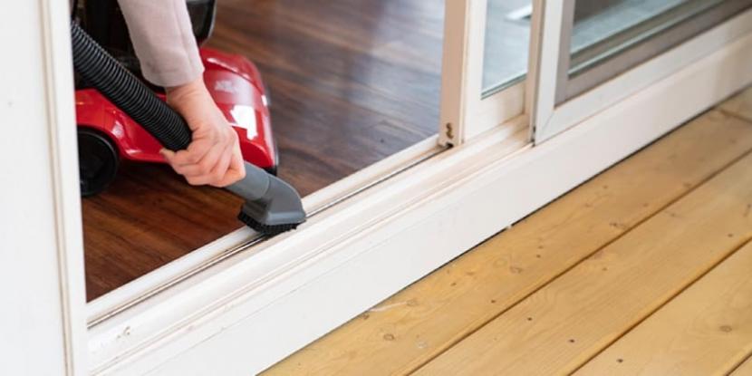 person hoovering door tracks