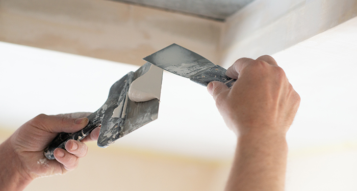 person plastering ceiling