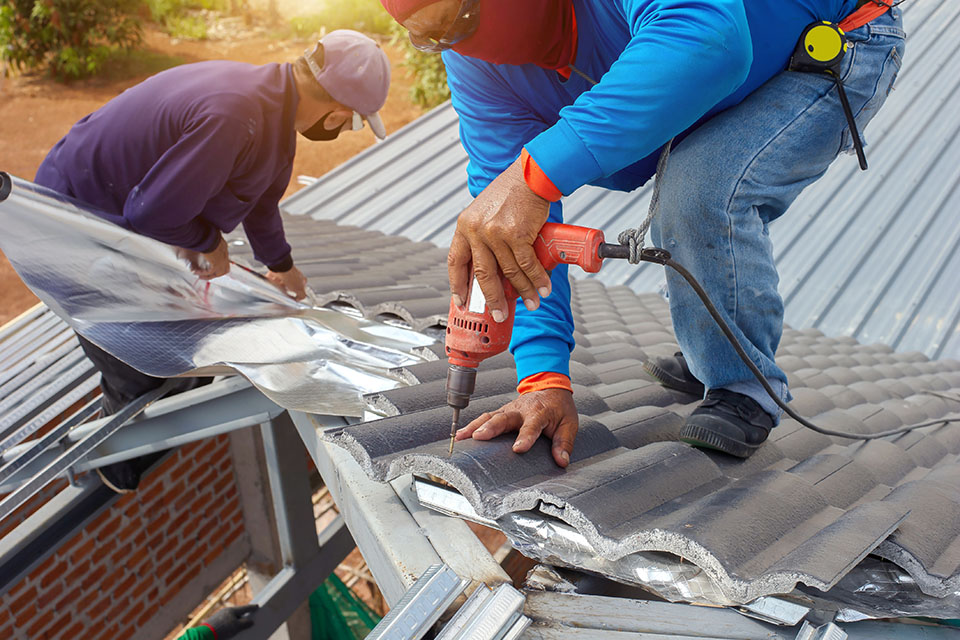 two people fixing roof