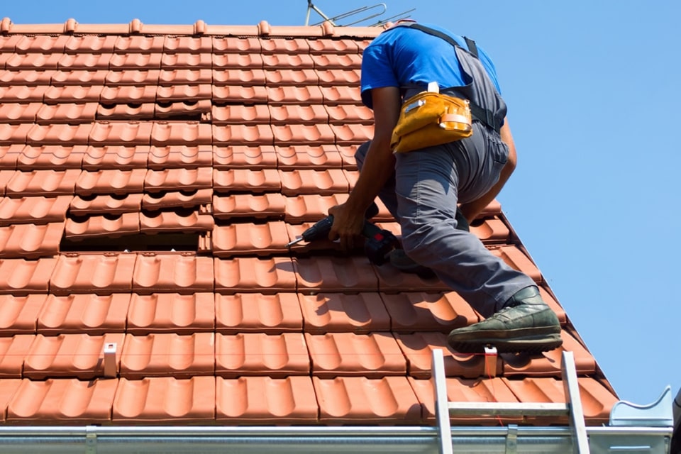 man repairing tiled roof
