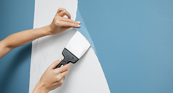 person removing blue wallpaper