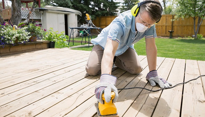 person sanding decking