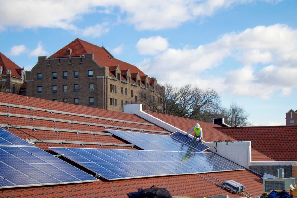 Man installing solar panels on roof