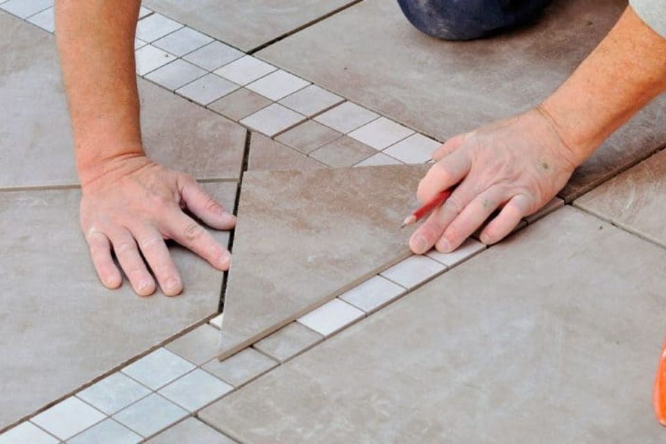 man tiling floor