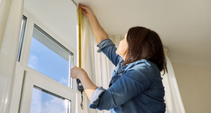 woman measuring windows and curtains